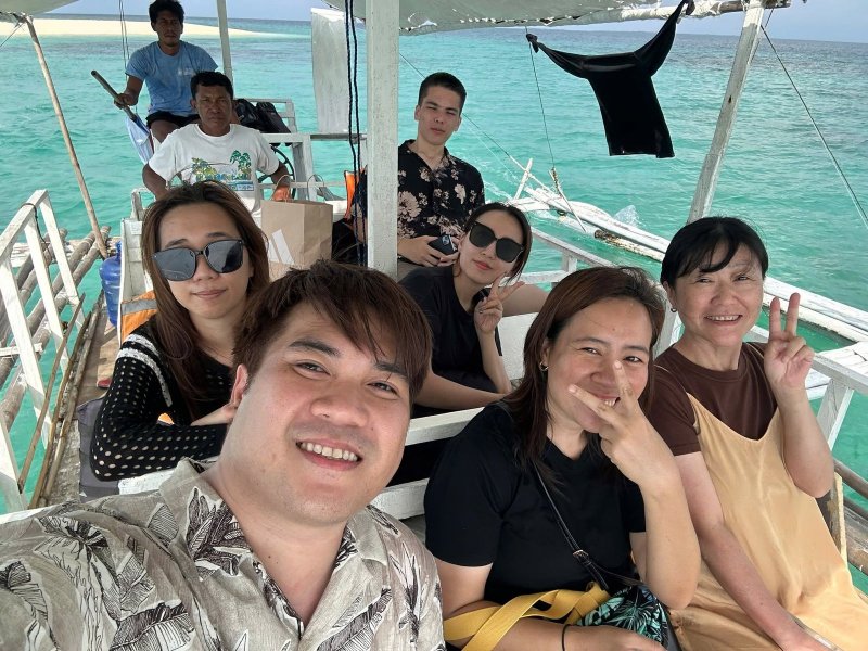 螃蟹船上的自拍合照,後方是碧綠海水與遠方沙洲