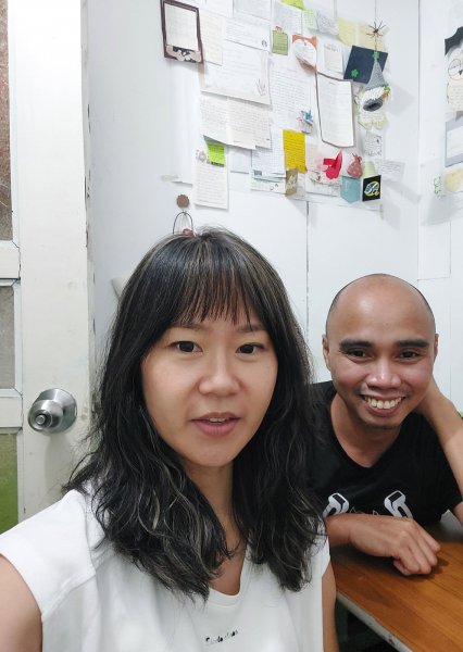 學員和老師在小教室合影，身後牆上貼滿手寫卡片