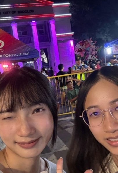 MassKara Festival 夜晚,學員和朋友在紫紅色燈光的建築前自拍