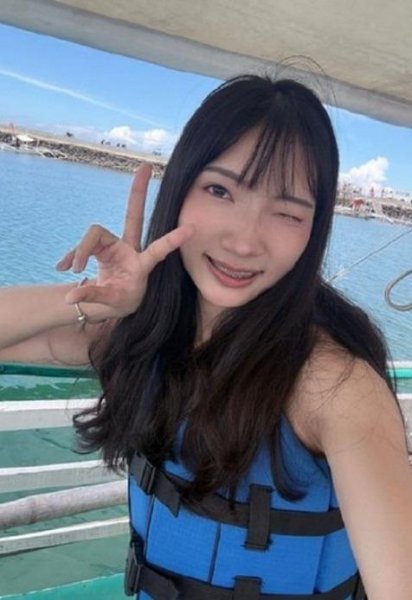 穿著藍色救生衣的學員在船上比 YA 自拍,背後是海面和岸邊