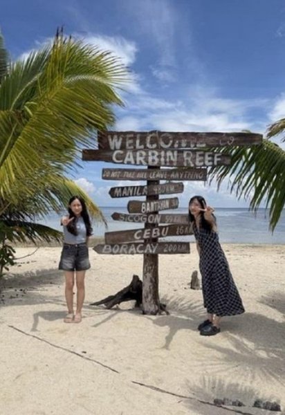 Carbin Reef 白沙灘上的木頭路標前,學員和朋友合照